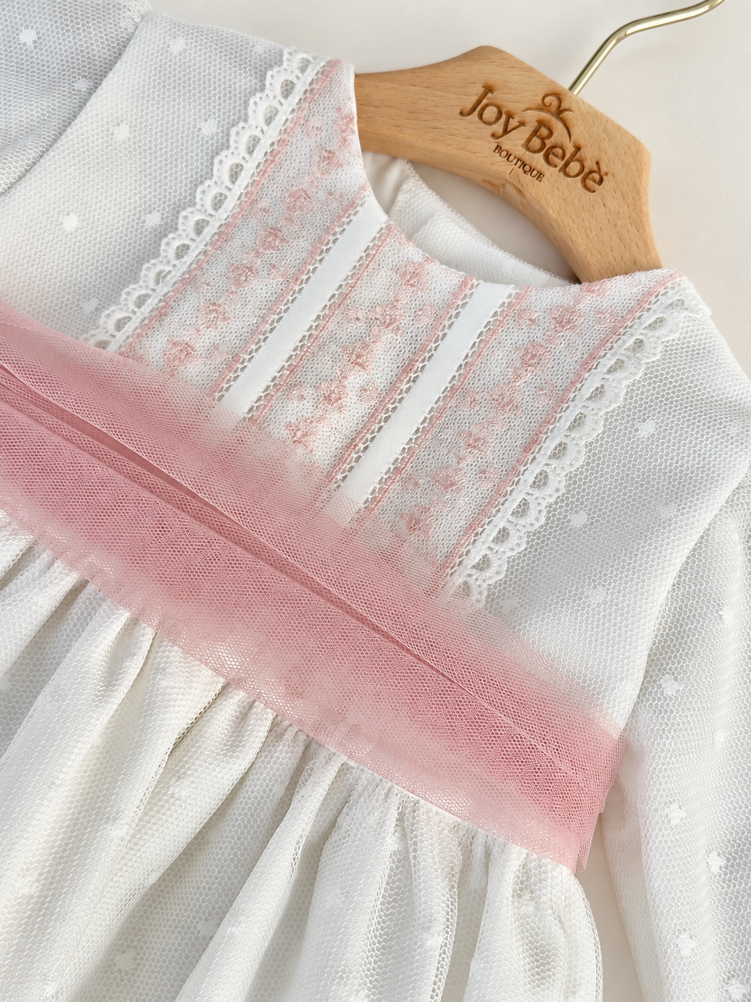 Abito Charo con fascia rosa su sfondo bianco caldo