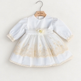 Abito Charo con ricami crema e fiore beige su sfondo bianco caldo