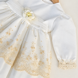 Abito Charo con ricami crema e fiore beige su sfondo bianco caldo