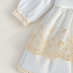 Abito Charo con ricami crema e fiore beige su sfondo bianco caldo