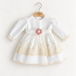 Abito Charo con ricami crema e fiore rosa su sfondo bianco caldo
