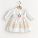 Abito Charo con ricami crema e fiore rosa su sfondo bianco caldo
