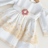 Abito Charo con ricami crema e fiore rosa su sfondo bianco caldo