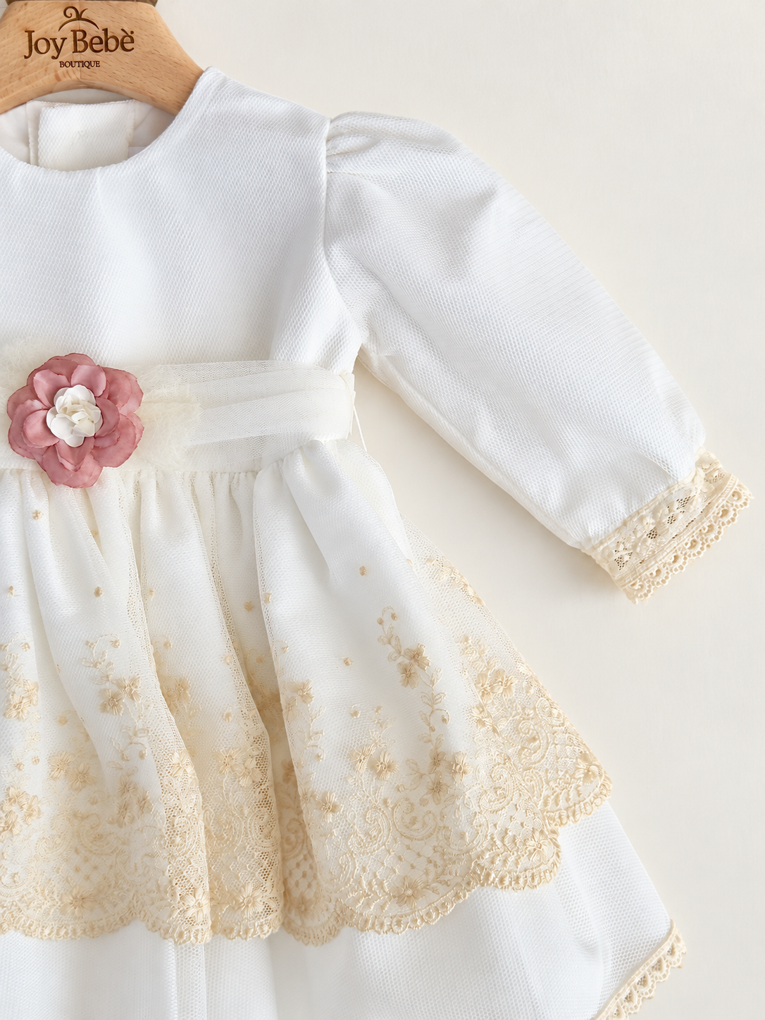 Abito Charo con ricami crema e fiore rosa su sfondo bianco caldo