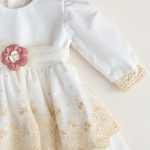 Abito Charo con ricami crema e fiore rosa su sfondo bianco caldo