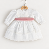 Abito Charo con fascia rosa su sfondo bianco caldo