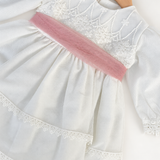 Abito Charo con fascia rosa su sfondo bianco caldo