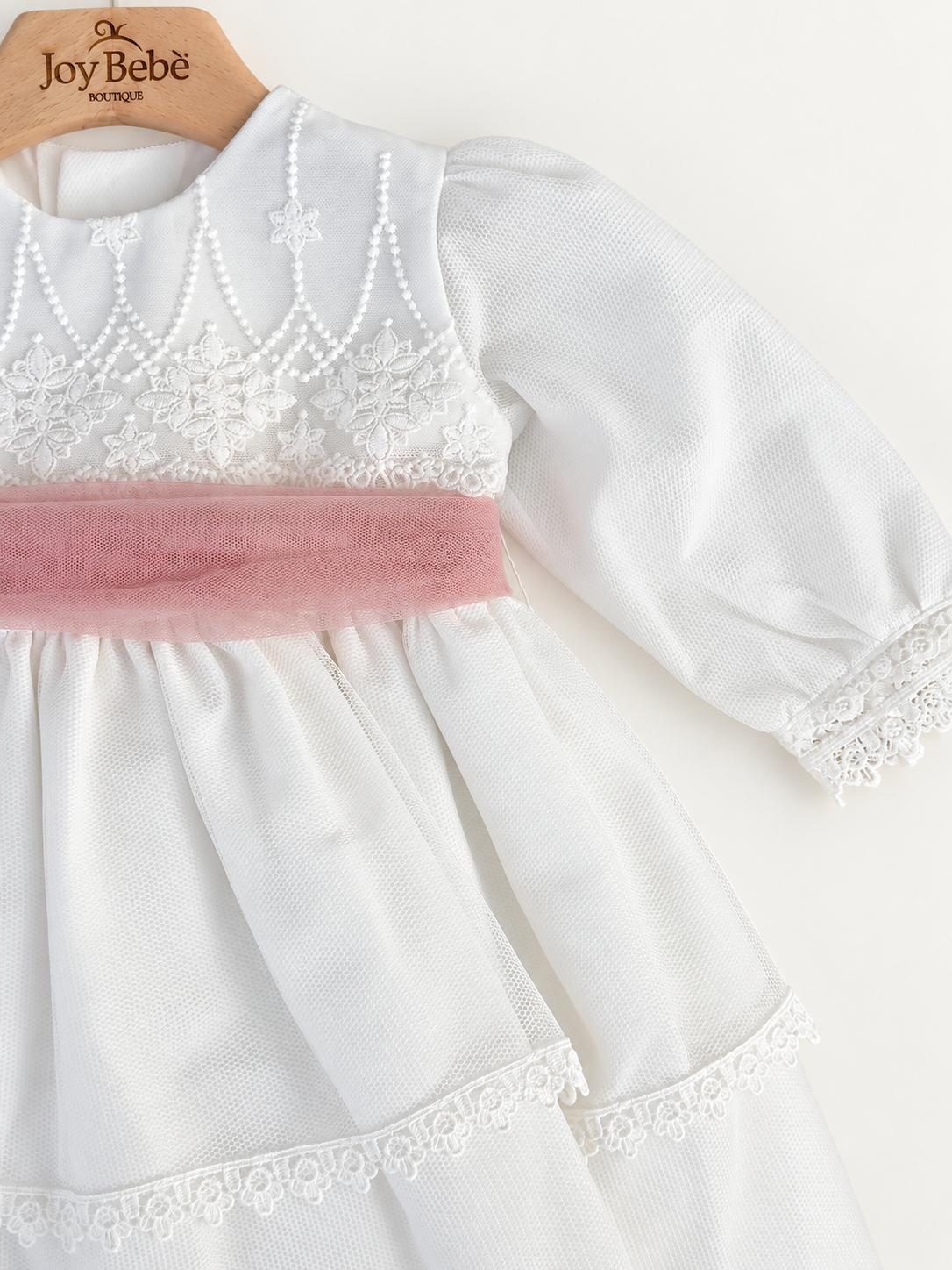 Abito Charo con fascia rosa su sfondo bianco caldo