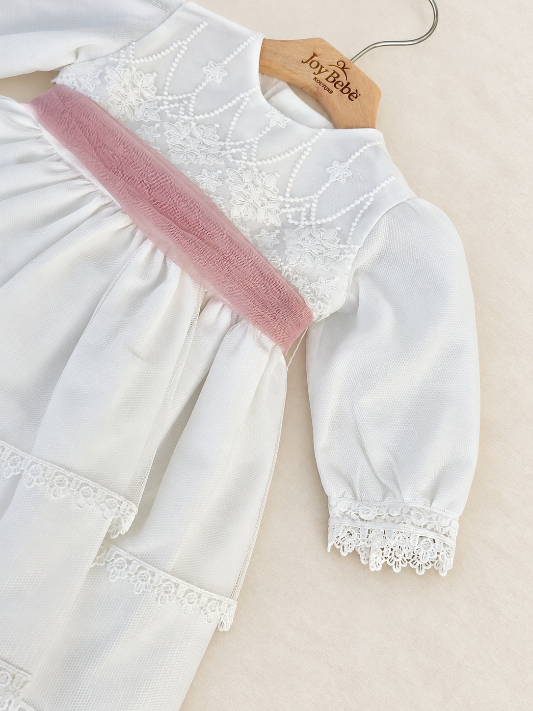 Abito Charo con fascia rosa su sfondo bianco caldo