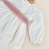 Abito Charo con fascia rosa su sfondo bianco caldo