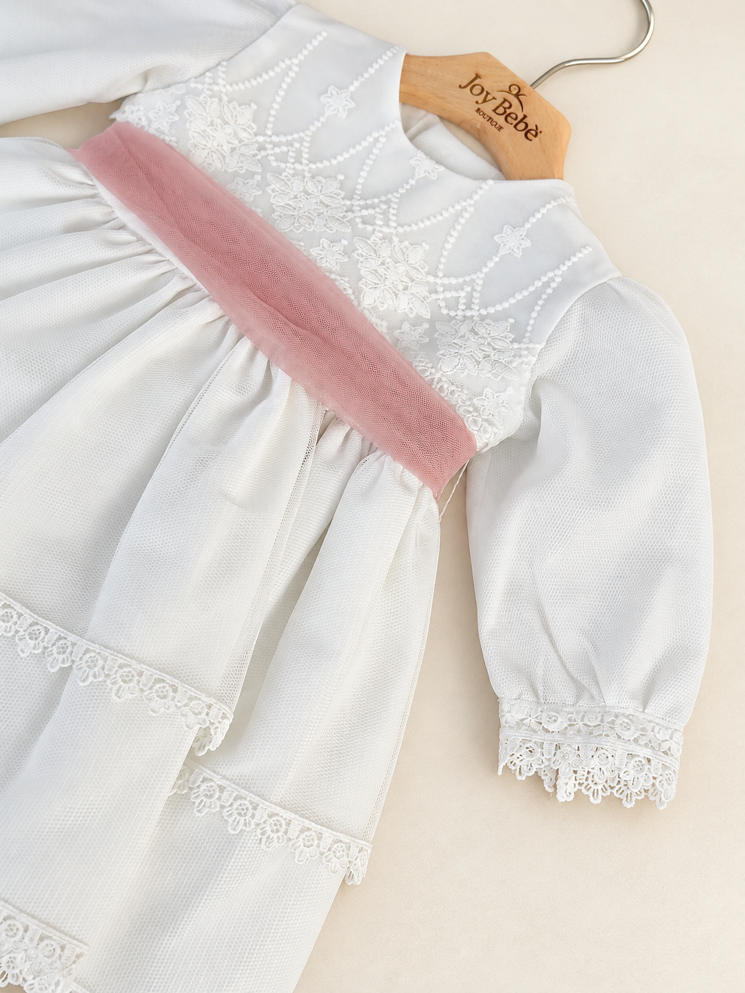 Abito Charo con fascia rosa su sfondo bianco caldo
