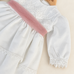 Abito Charo con fascia rosa su sfondo bianco caldo