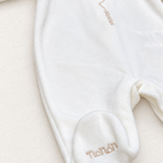 Tutina Nanan, dettaglio su sfondo bianco caldo naturale